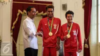 Presiden Jokowi menyalami pasangan ganda campuran Tontowi Ahmad/Liliyana Natsir yang meraih medali emas saat menerima Kontingen Indonesia untuk Olimpiade Rio De Janeiro Brasil 2016, di Istana Merdeka, Jakarta, Rabu (24/8). (Liputan6.com/Faizal Fanani)