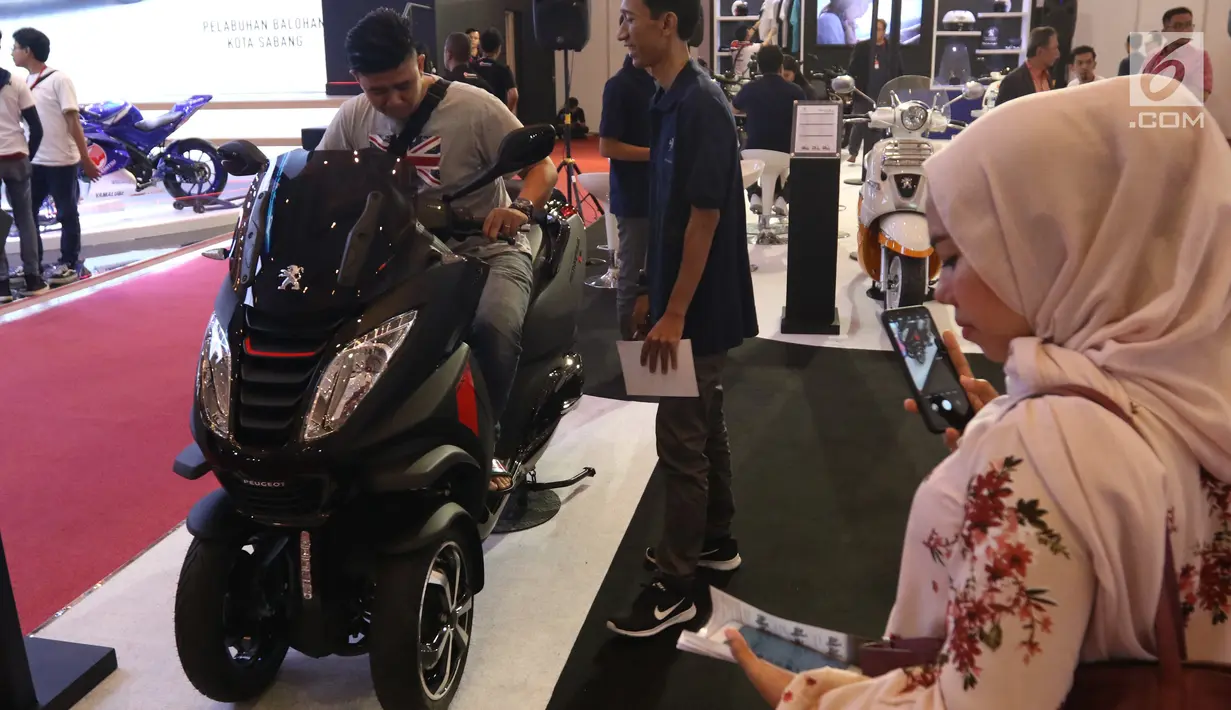 Pengunjung menjajal motor dalam pameran Indonesia Motorcycle Show (IMOS) 2018 di JCC, Jakarta, Rabu (31/10). Selain pameran, IMOS 2018 juga akan memberikan ruang edukasi berbagai hal mengenai otomotif. (Liputan6.com/Angga Yuniar)