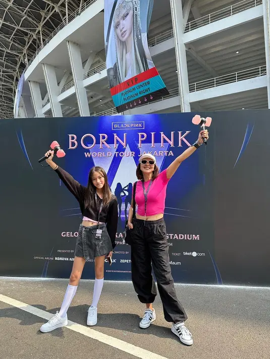 Donna mengenakan kaos merah muda dan celana panjang hitam. Melengkapi penampilannya dengan sepatu putih, kaca mata hitam, topi putih dan lighstick Blackpink. Sedangkan putrinya mengenakan kemeja panjang hitam dan juga memegang lighstik.  "We are ready for @blackpinkofficial Born Pink World Tour," tulis Donna. [Instagram/dagnesia]
