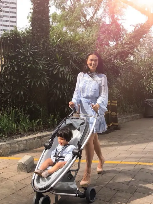 Seperti foto yang baru diunggahnya beberapa jam lalu, Atiqah tampil cantik banget saat mendorong Salma yang duduk manis di strollernya. Atiqah mengenakan dress berwarna birunya dan pesonanya sangat memikat. (Instagram/atiqahhasiholan)