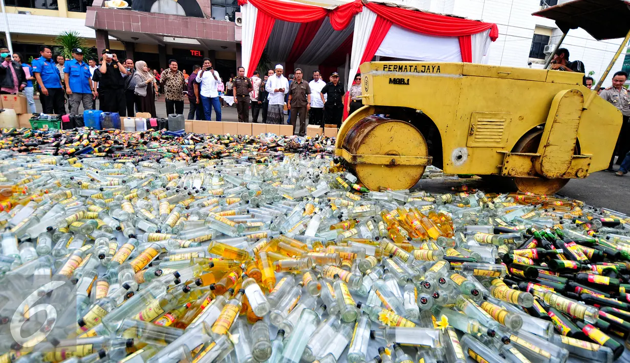 Petugas mengoperasikan Alat Berat untuk menghancurkan botol minuman keras (miras) di Mapolres Jakarta Selatan, Rabu (10/6/2015). Pemusnahan 8.000 botol miras untuk menekan peredaran miras khususnya menjelang bulan Ramadan. (Liputan6.com/Yoppy Renato)