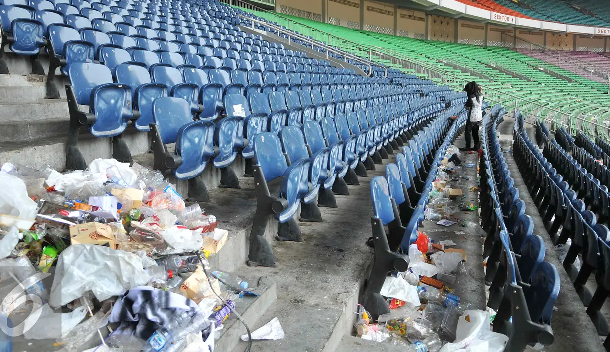 Petugas kebersihan membersihkan tumpukan sampah usai pertandingan final piala presiden di Stadion GBK, Jakarta (19/10/15). Pertandingan final tersebut dimenangkan oleh Persib Bandung 2-0. (Liputan6.com/Gempur M Surya).