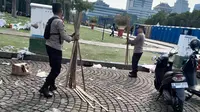 Personel Polri Sigap Bersih-Bersih Kawasan Monas Usai Peringatan May Day