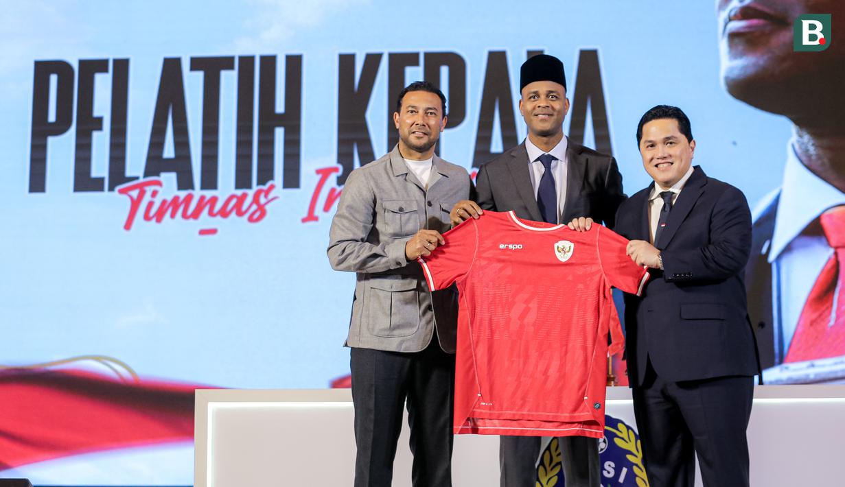 Pelatih kepala baru Timnas Indonesia, Patrick Kluivert (tengah) berfoto bersama ketua umum PSSI, Erick Thohir (kanan) dan asisten pelatih baru Timnas Indonesia, Denny Lanzaat berfoto bersama sambil memegang jersey pada acara konferensi pers mengenai perkenalan pelatih baru Timnas Indonesia di Hotel Mulia, Senayan, Jakarta, Minggu (12/01/2025). (Bola.com/Bagaskara Lazuardi)