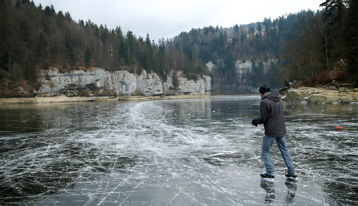 Seorang pria asyik bermain ice skating atau seluncur es di atas sungai Doubs yang membeku di perbatasan Perancis Les Brenets, Swiss, Senin (2/1). Sungai ini menjadi objek wisata es yang diminati warga. (REUTERS/Denis Balibouse)