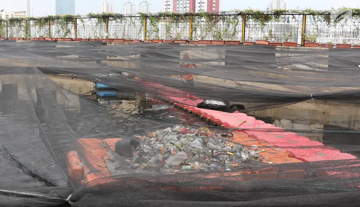 Petugas menjaring sampah plastik yang terbawa aliran air Kali Item di Jakarta, Minggu (4/11). Buruknya perilaku warga yang membuang sampah sembarangan menyebabkan sungai-sungai di Jakarta kerap dipenuhi sampah plastik. (Liputan6.com/Immanuel Antonius)