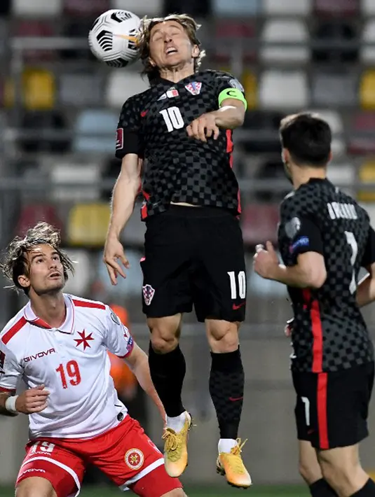 Pemain Kroasia Luka Modric (tengah) menyundul bola melewati pemain Malta Bjorn Kristensen (kiri) pada pertandingan Grup H kualifikasi Piala Dunia 2022 di Stadion Rujevica, Rijeka, Kroasia, Selasa (30/3/2021). (Denis LOVROVIC/AFP)