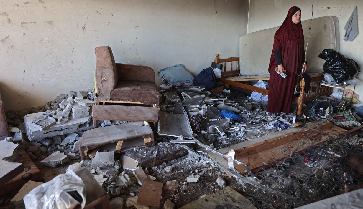 Seorang wanita Palestina berdiri di tengah reruntuhan bangunan tempat tinggal yang rusak setelah serangan Israel di Kota Gaza pada Kamis 4 Juni 2026. (Omar AL-QATTAA/AFP)
