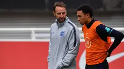 Pelatih Inggris, Gareth Southgate (kiri) berbincang dengan bek Trent Alexander-Arnold saat sesi latihan Burton-on-Trent (6/9/2019). Di grup A Inggris menempati posisi pertama dengan poin enam sedangkan Bulgaria diposisi terakhir poin dua. (AFP Photo/Paul Ellis)