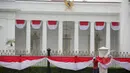 Pekerja memasang kain renda berwarna merah putih dipagar depan Istana Merdeka, Jakarta, Senin (13/4/2015). Jelang Konferensi Asia Afrika (KAA) ke-60 di Bandung pada 24 April mendatang, Istana Merdeka mulai dipercantik. (Liputan6.com/Faizal Fanani)