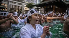 Penganut Shinto mandi dengan air dingin di Kuil Teppozu Inari, Tokyo, Jepang, 8 Januari 2023. Ritual Tahun Baru ini dilakukan untuk memurnikan jiwa dan raga. (Philip FONG/AFP)