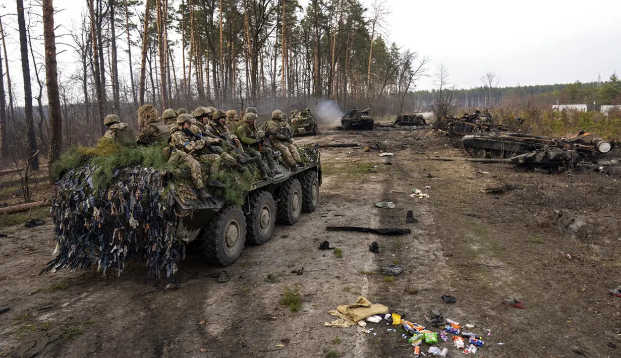 Tentara Ukraina naik kendaraan lapis baja di samping tank Rusia yang hancur di pinggiran Kiev, Ukraina, 31 Maret 2022. Pasukan Rusia menembaki pinggiran Kota Kiev, dua hari setelah Kremlin mengumumkan akan secara signifikan mengurangi operasi dekat Ibu Kota dan Chernihiv. (AP Photo/Rodrigo Abd)
