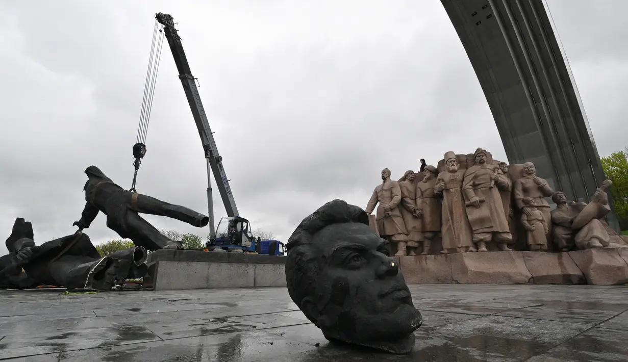 <p>Sebuah monumen era Soviet untuk persahabatan antara Rusia dan Ukraina terlihat selama pembongkarannya, di tengah invasi Moskow di Kiev tengah, Ukraina, Selasa (26/4/2022). Patung perunggu setinggi 8 meter itu menggambarkan seorang pekerja Ukraina dan Rusia di atas alas, memegang tinggi-tinggi tatanan persahabatan Soviet. Genya SAVILOV / AFP)</p>