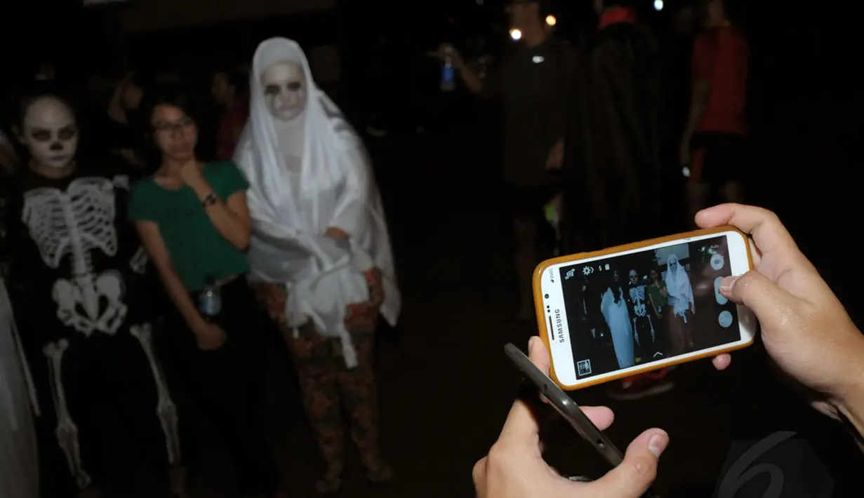 Beberapa orang berfoto bersama menggunakan kostum menyeramkan saat merayakan perayaan Halloween di kawasan Stadion Gelora Bung Karno, Jakarta, Kamis (30/10/2014). Halloween merupakan tradisi perayaan malam 31 Oktober. (Liputan6.com/Helmi Fithriansyah)