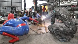 Seorang seniman mengelas bagian-bagian robot di "Ban Hun Lek", atau "Rumah Robot Baja", di Provinsi Ang Thong, Thailand tengah (5/6/2020). Rongsokan mekanik yang tampaknya tidak berharga disulap oleh pengrajin bengkel tersebut menjadi karya seni unik dan eksentrik. (Xinhua/Zhang Keren)