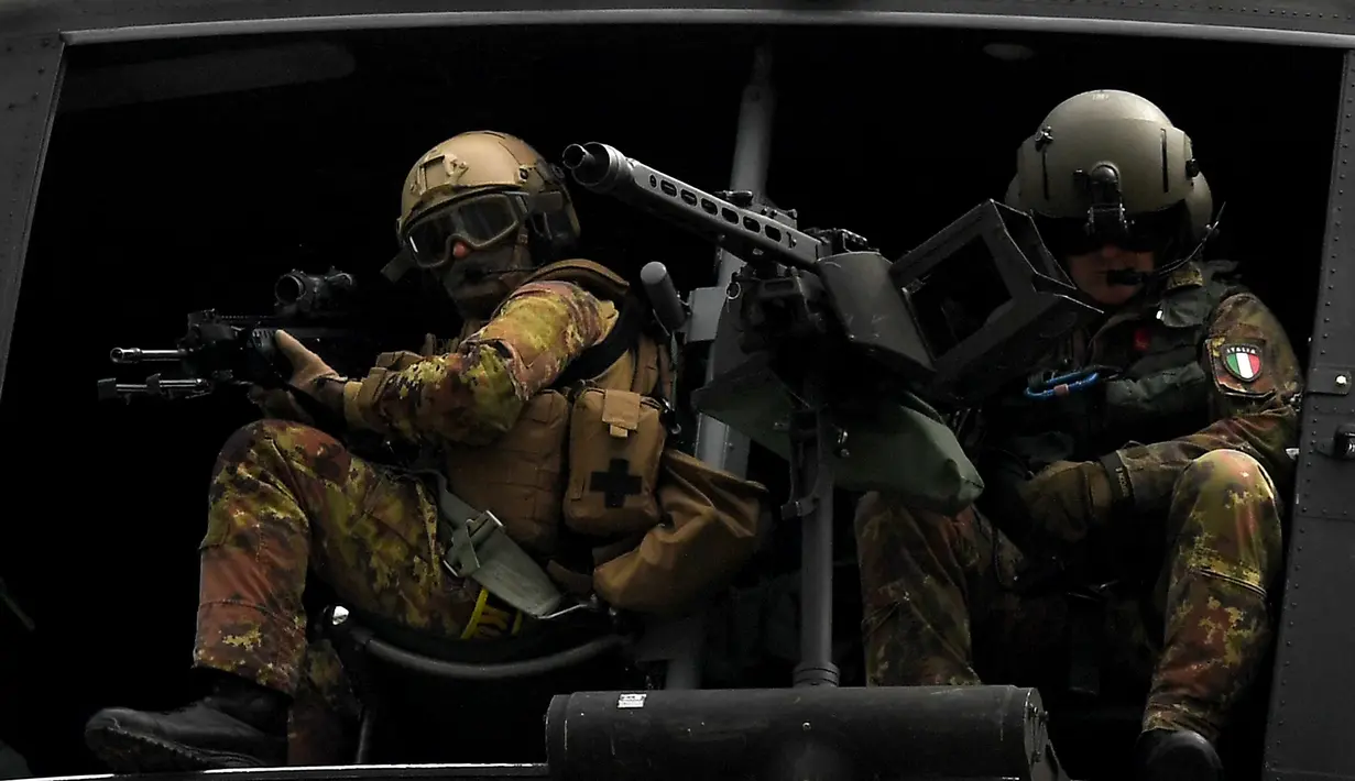 Dua tentara Italia berada di helikopter saat mengikuti latihan militer di sebuah kamp pelatihan di Tarquinia, dekat Roma, (21/5).  (AFP Photo/Tiziana Fabi)