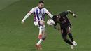Pemain Real Valladolid, Luis Perez, berebut bola dengan pemain Real Madrid, Vinicius Junior, pada laga Liga Spanyol di Stadion Jose Zorrila, Minggu (21/2/2021). Real Madrid menang dengan skor 1-0. (AP/Alvaro Barrientos)