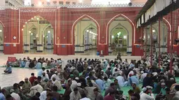 Umat Islam Pakistan berbuka puasa bersama di sebuah masjid di Karachi pada 7 Mei 2019. Ketika bulan suci Ramadan mulai di Pakistan, banyak masyarakat muslim memanfaatkan buka puasa gratis yang disponsori oleh badan-badan amal dan orang-orang kaya. (RIZWAN TABASSUM / AFP)