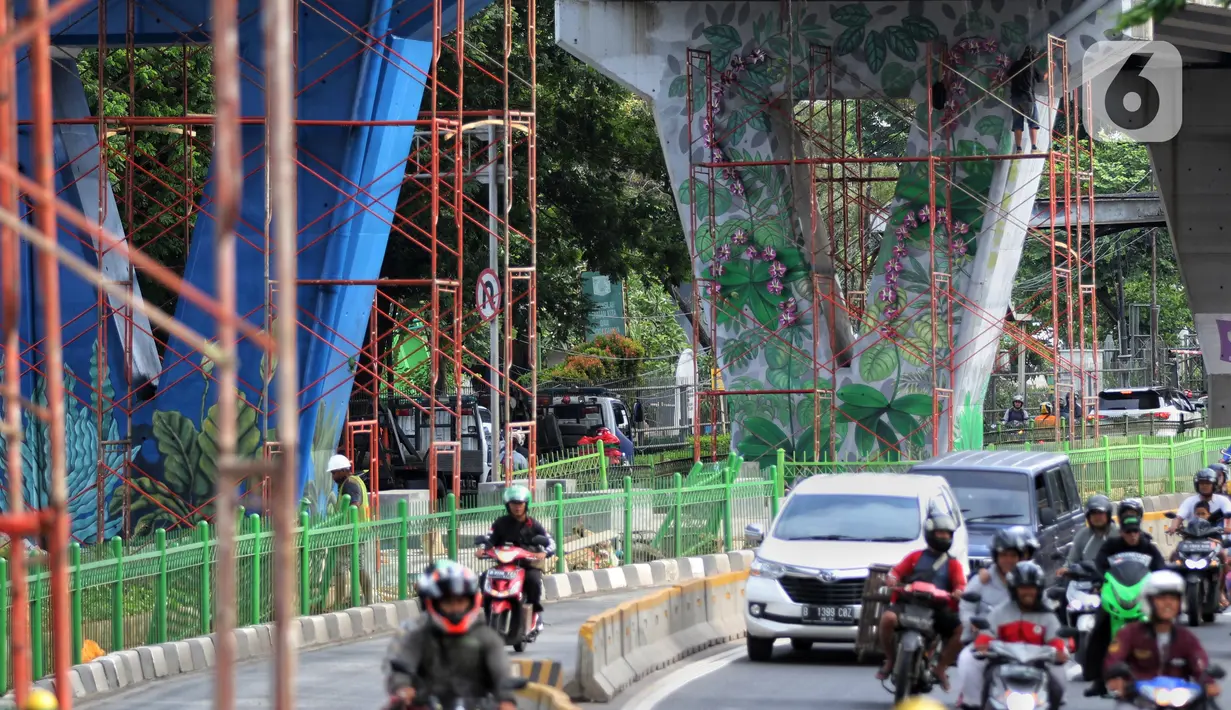 Pengendara melintas dekat dinding Jalan Layang Pesing yang berhias mural di Jakarta Barat, Sabtu (7/12/2019). Mural pada jalan layang sepanjang 1,5 kilometer tersebut merupakan bagian dari program Pemerintah Provinsi DKI Jakarta dalam mempercantik Ibu Kota. (Liputan6.com/Johan Tallo)