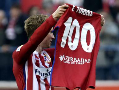 Pemain Atletico Madrid, Fernando Torres mengangkat baju bertuliskan 100 gol yang telah dicetaknya bersama Atletico Madrid pada Lanjutan La Liga Spanyol di Stadion Vicente Calderon, Sabtu (6/2/2016).  (EPA/Javier Lizon)