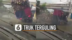 Video sebuah truk bermuatan kayu terguling akibat jalanan berlubang viral di media sosial.