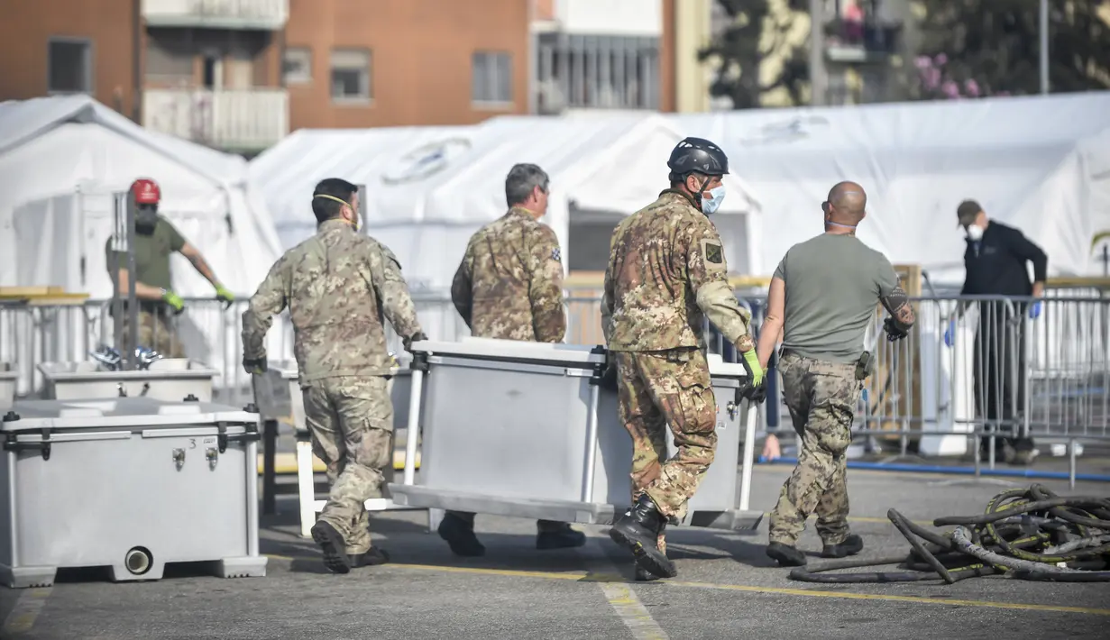 Tentara membawa peralatan rumah sakit lapangan darurat Samaritan's Purse di Cremona, Italia, Jumat, 20 Maret 2020. Rumah sakit lapangan ini dibangun untuk merawat pasien virus corona COVID-19 yang terus melonjak. (Claudio Furlan/LaPresse via AP)
