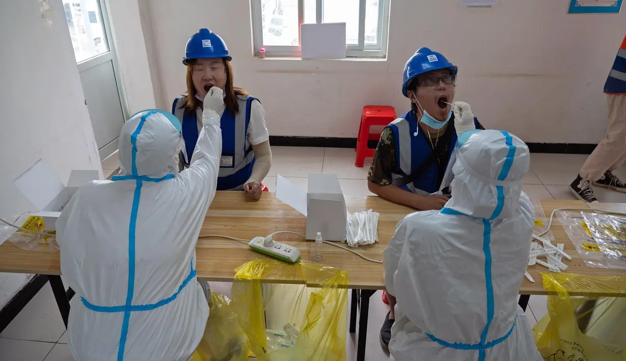 Staf medis mengambil sampel usap tenggorokan dari para pekerja konstruksi di lokasi pengambilan sampel sementara di Distrik Daxing, Beijing, China (2/7/2020). Sebanyak 1.353 pekerja di lokasi konstruksi tersebut menjalani pengambilan sampel tes asam nukleat pada Kamis (2/7). (Xinhua/Cai Yang)