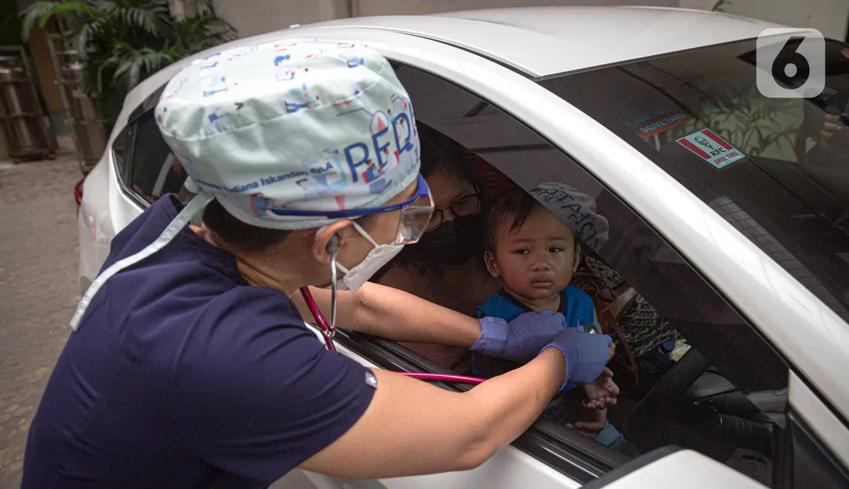Petugas memeriksa kesehatan serta imunisasi pasien anak di RSIA Bunda, Jakarta, Jumat (18/3/2022). Pemeriksaan dilakukan drive thru guna memberi rasa aman orangtua, khususnya ibu yang ingin melaksanakan imunisasi serta pemeriksaan nonpenyakit di tengah pandemi COVID-19. (Liputan6.com/Faizal Fanani)