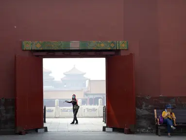 Pengunjung mengenakan masker saat berjalan di Kota Terlarang, Beijing, China, Jumat (1/5/2020). Kota Terlarang kembali dibuka setelah ditutup lebih dari tiga bulan karena pandemi virus corona COVID-19. (AP Photo/Mark Schiefelbein)