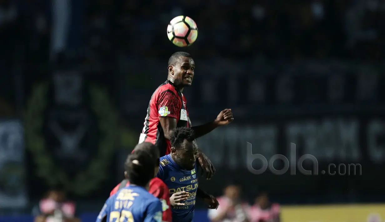 Pemain Persipura Jayapura, Dominggus Fakdawer membuang bola dari kejaran pemain Persib Bandung, Michael Essien pada lanjutan Liga 12017 di Stadion GBLA, Bandung, Minggu (7/5/2017). Persib bandung menang 1-0. (Bola.com/Nicklas Hanoatubun)