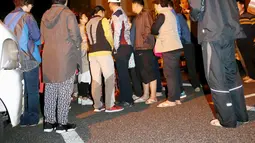 Sejumlah orang berhamburan ke jalan di depan sebuah hotel setelah gempa bumi mennguncang Kumamoto, Jepang selatan, Kamis (14/4). Gempa 6,4 SR itu juga mengakibatkan lebih dari 20 bangunan rumah hancur dan kebakaran di Prefektur Kumamoto. (REUTERS/Kyodo)