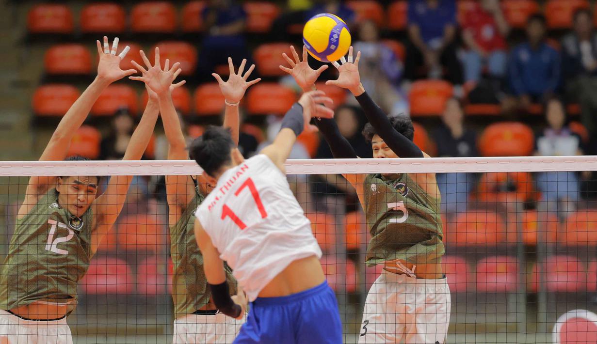 Vietnam berhasil menemukan ritme permainan dan menutup set pembuka dengan kemenangan 25-21. Tampak dalam foto, pemain voli putra Indonesia, Rivan Nurmulki (kiri) dan Boy Arnez Arabi (kanan hadap lensa) melakukan block smash saat melawan Vietnam di babak semifinal SEA Games 2025 di Indoor Stadium Huamark, Bangkok, Thailand, Kamis (18/12/2025). (Bola.com/Bagaskara Lazuardi)