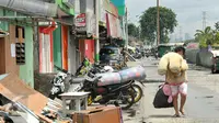 Seorang warga mengangkut barang miliknya di kawasan Kalijodo, Jakarta, Kamis (25/2). Hari ini, surat peringatan kedua (SP2) untuk mengosongkan/membongkar sendiri bangunan sudah terpasang di kawasan tersebut. (Lputan6.com/Gempur M Surya)