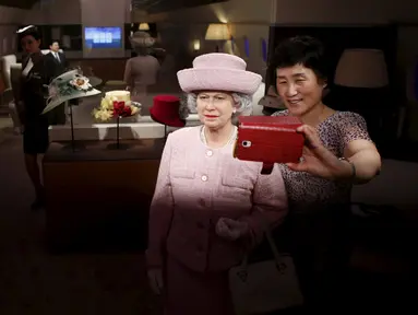 Seorang wanita berselfie dengan patung lilin Ratu Inggris Elizabeth II di Grevin Wax Museum, Korea Selatan, Kamis (30/7/2015). Museum lilin asal Perancis ini telah membuka cabang pertamanya di Asia. (REUTERS/Kim Hong-Ji)