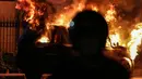 Kobaran api melahap sebuah mobil di Jalan Asia Afrika, Jakarta, Kamis (18/3/2021) dinihari. Diduga penyebab api adalah akibat dari hubungan pendek arus listrik yang terjadi di bagian mesin. (Liputan6.com/Johan Tallo)