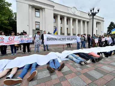 Sejumlah orang menggelar aksi unjuk rasa di depan Parlemen Ukraina di Kiev, Selasa (6/6). Mereka mengingatkan pemerintah bahwa 67 orang Ukraina meninggal setiap hari dari penyakit. (AFP/SERGEI SUPINSKY)