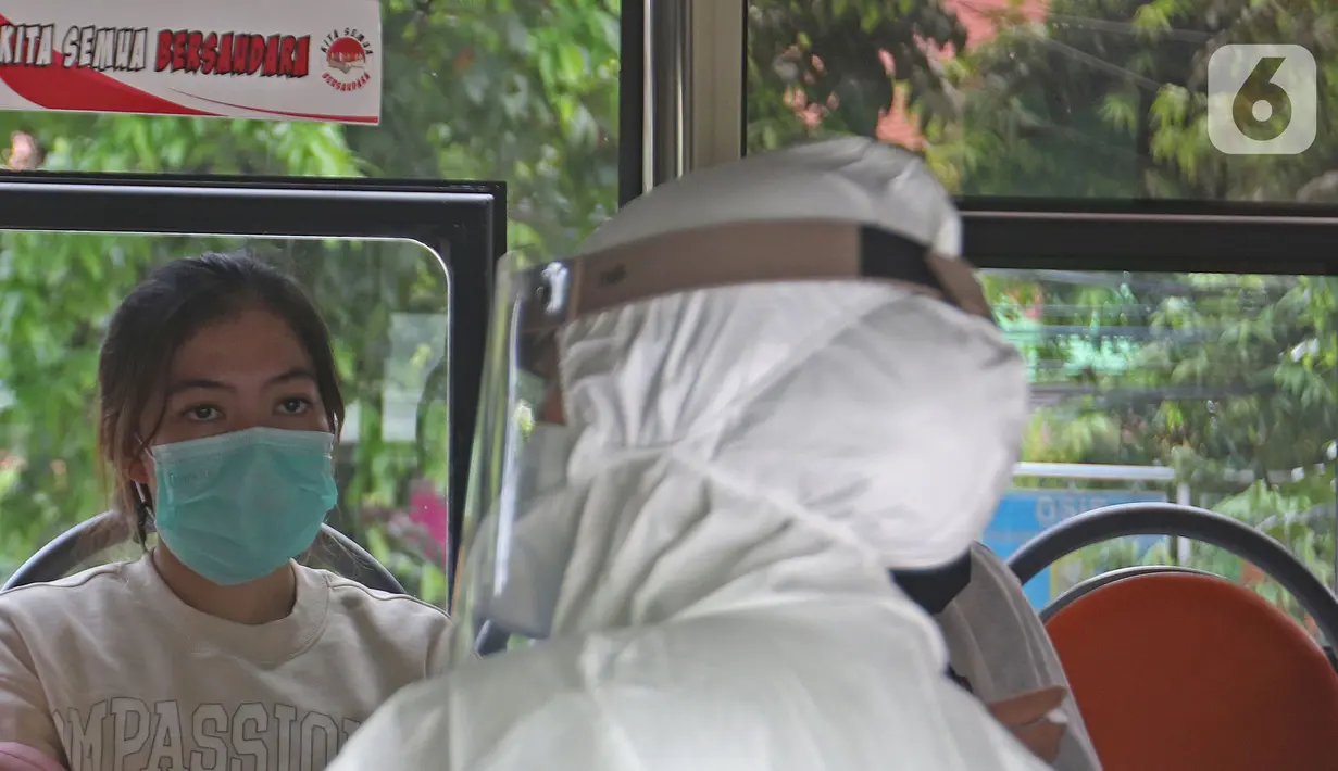 Pasien Covid-19 berada di dalam bus sekolah di Puskesmas Kecamatan Ciracas, Jakarta, Kamis (10/06/2021). Kasus positif di Jakarta bertambah 2.096 orang, sehingga total kasus positif bertambah menjadi 440.554 orang. (Liputan6.com/Herman Zakharia)
