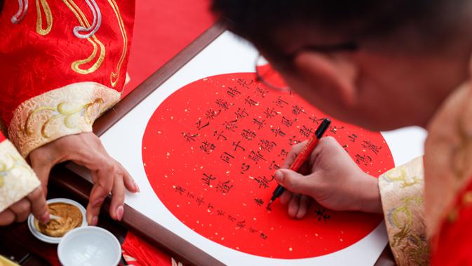 Seorang pengantin pria menandatangani akta pernikahan dalam sebuah upacara pernikahan tradisional yang diadakan di Guiyang, ibu kota Provinsi Guizhou, China barat daya, pada 16 November 2020. (Xinhua/Ou Dongqu)