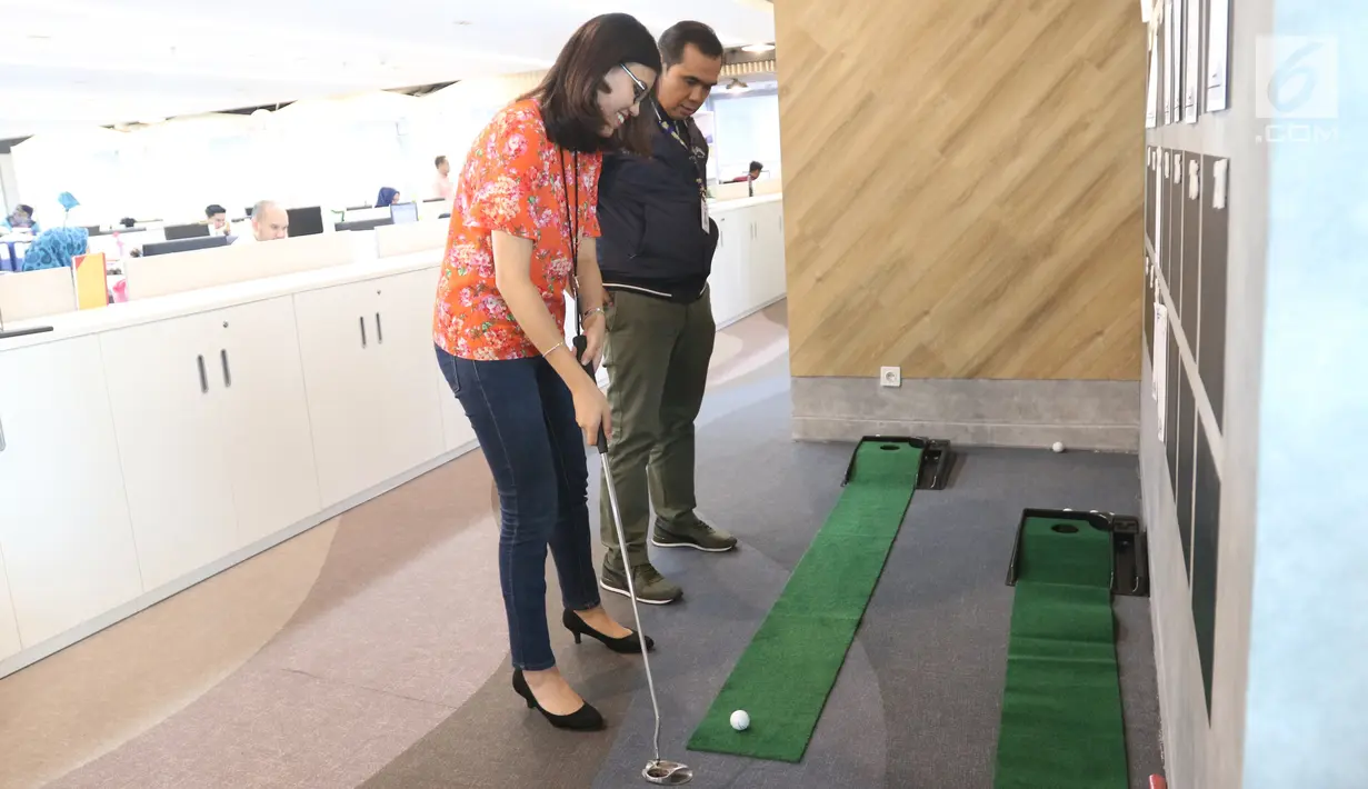 Pegawai bermain golf mini di Plaza Mandiri, Jakarta, Jumat (26/10). Atas inovasi pegawai milenial, Bank Mandiri masuk dalam top 11 tempat bekerja terbaik di dunia versi Forbes. (Liputan6.com/Angga Yuniar)