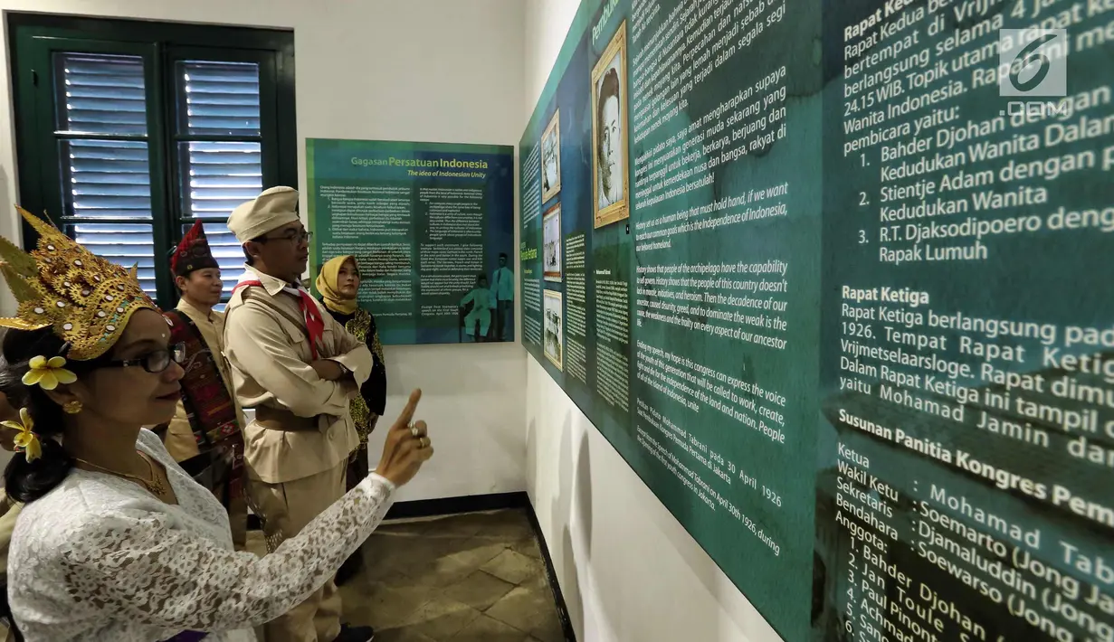 Pengunjung mengenakan kostum adat dan pejuang memerhatikan kutipan pesan kebangsaan di Museum Sumpah Pemuda, Jakarta, Jumat (27/10). Jelang peringatan 89 tahun Sumpah Pemuda, museum ini ramai dikunjungi masyarakat. (Liputan6.com/Faizal Fanani)
