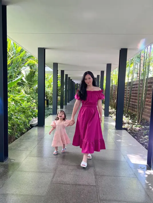 Asmirandah and her little princess dibalut gaun yang serasi. Asmirandah kembali tampil dengan off-the-shoulder long dress dengan aksen kerut yang manis, namun kali ini dalam warna fuschia. Foto: Instagram.