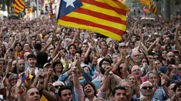 Sejumlah orang bereaksi ketika Parlemen Catalonia mendeklarasikan kemerdekaan dari Spanyol di luar gedung parlemen di Barcelona, Jumat (27/10). Sejumlah pendukung kemerdekaan, turun ke jalan dan menyanyikan lagu tradisional Catalan. (AP/Emilio Morenatti)