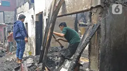 Warga melihat sisa permukiman yang terbakar di Jalan Keadilan Dalam, Taman Sari, Jakarta Barat, Senin (19/4/2021). Kebakaran permukiman padat tersebut mengakibatkan sebanyak 200 rumah hangus terbakar dan sekitar 1.000 warga terpaksa mengungsi. (Liputan6.com/Herman Zakharia)