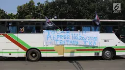 Sebuah spanduk terpampang di bus yang mengangkut buruh saat melakukan aksi May Day 2018 di Jalan Medan Merdeka Timur, Jakarta, Selasa (1/5). (Liputan6.com/Arya Manggala)