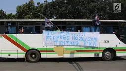 Sebuah spanduk terpampang di bus yang mengangkut buruh saat melakukan aksi May Day 2018 di Jalan Medan Merdeka Timur, Jakarta, Selasa (1/5). (Liputan6.com/Arya Manggala)