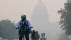 Seorang pengendara sepeda menggowes di bawah selimut kabut yang menutupi sebagian Capitol AS di Washington, DC, pada 8 Juni 2023. (Photo by Mandel NGAN / AFP)