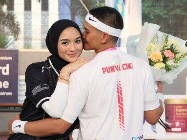 Pose pasangan artis, Citra Kirana dan Rezky Aditya, setelah pertandingan tenis tunggal putra Turnamen Olahraga Selebriti Indonesia yang berlangsung di GOR Universitas Negeri Jakarta, Sabtu (29/7/2023). (Bola.com/Abdul Aziz)