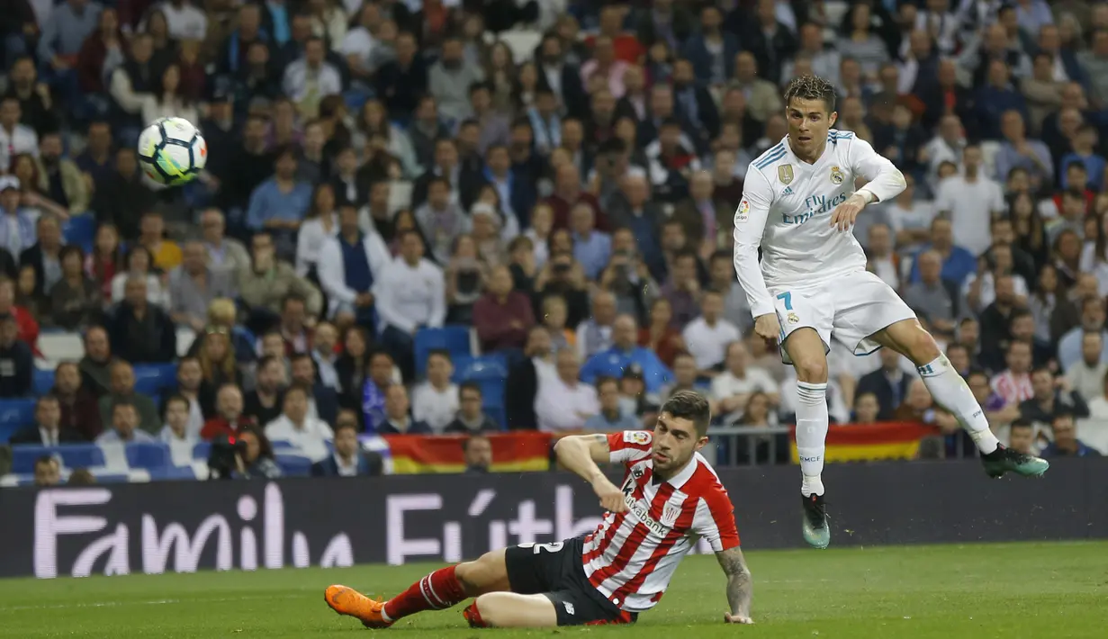 Tembakan keras Cristiano Ronaldo melewati adangan pemain Athletic Bilbao, Unai Nunez pada lanjutan La Liga Santander di Santiago Bernabeu stadium, Madrid, (18/4/2018). Real Madrid bermain imbang 1-1 dengan Bilbao. (AP/Francisco Seco)