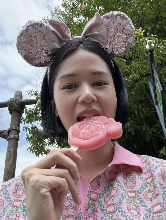 <p>Masih di Disneyland, Laura Basuki tampil tanpa makeup sambil menggigit ice cream. Tampil dengan bondu Minnie Mouse pinknya. (@laurabas)</p>