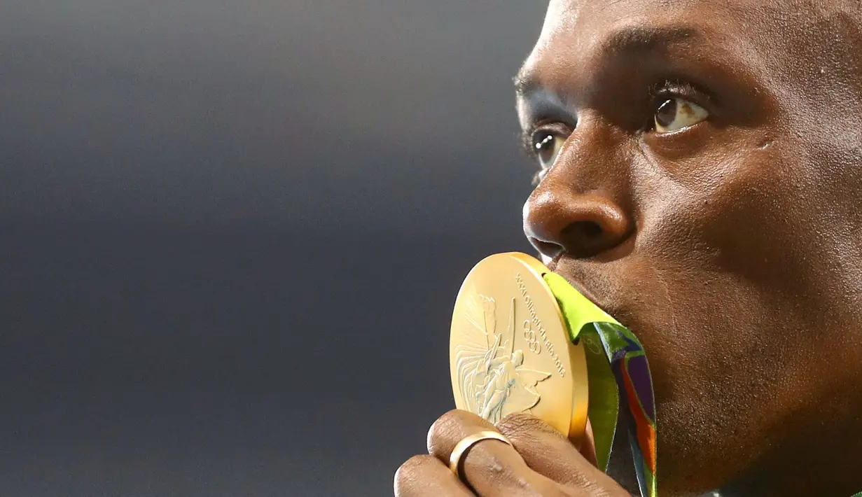  Sprinter Jamaika, Usain Bolt, mencium medali emas lari 100 m Olimpiade Rio 2016 yang diraihnya dalam final di Olympic Stadium, Rio de Janeiro, Brasil, (15/8/2016). (Reuters/Leonhard Foeger)